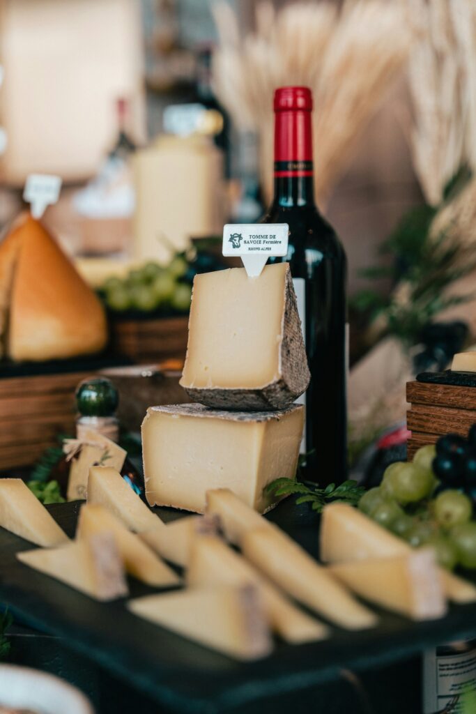 a table topped with lots of cheese and a bottle of wine