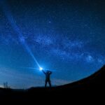 silhouette of man holding flashlight